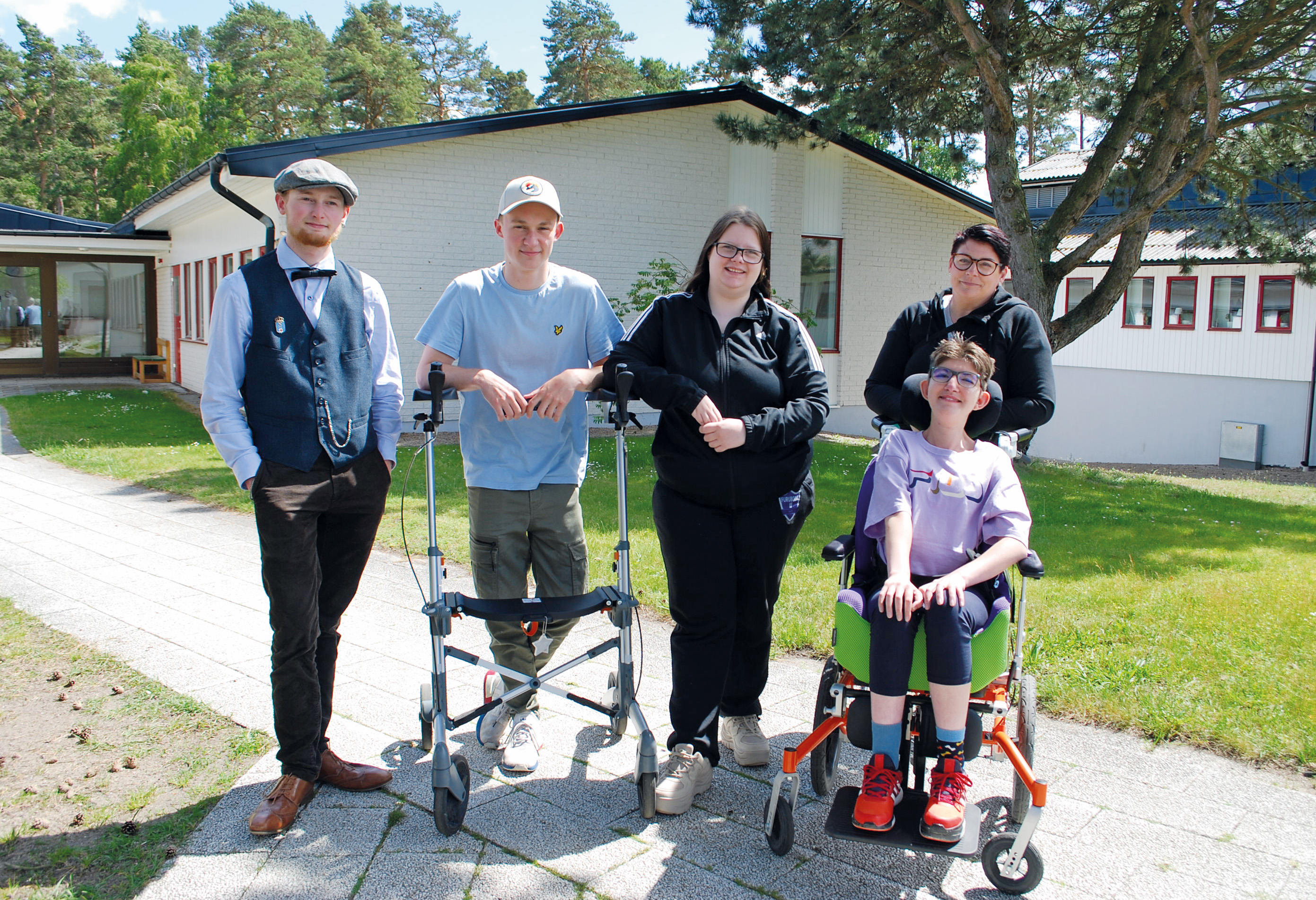 En grupp med fem personer, där en sitter i rullstol