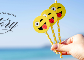 En hand håller i olika smileys
