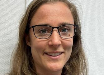 Leende kvinna med långt hår och glasögon