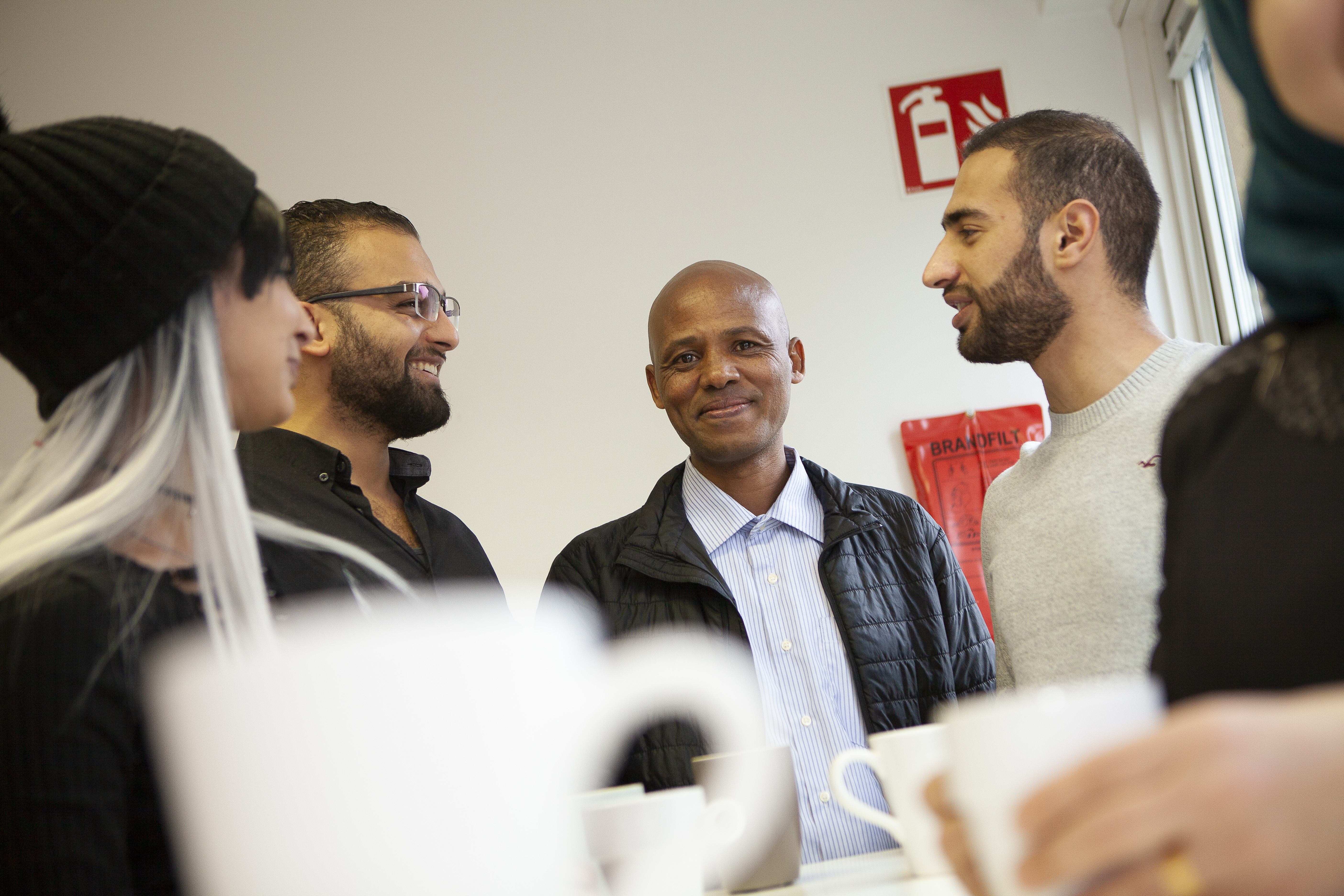 En grupp personer och i förgrunden en kaffekopp