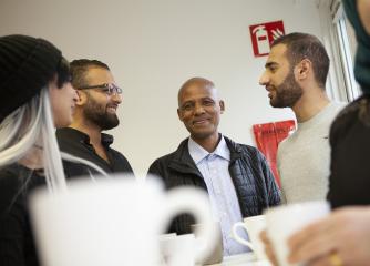 En grupp personer och i förgrunden en kaffekopp