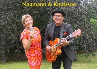 Två glada personer, en med en mick den andra med en gitarr