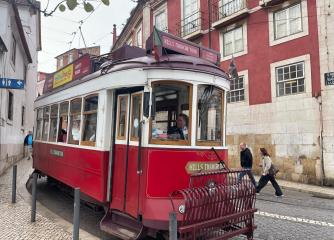 röd spårvagn på en gata i Lissabon