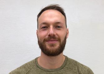 Leende man med mörkt skägg
